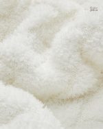 Plaid blanc chaleureux, accessoire incontournable du salon