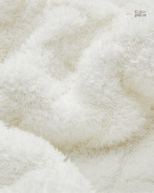 Plaid blanc chaleureux, accessoire incontournable du salon