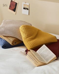 Couverture pilou pilou beige, idéale pour se réchauffer avec style