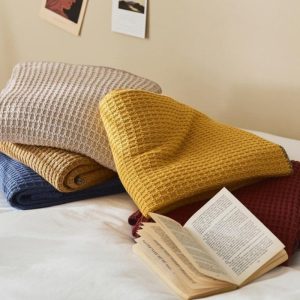 Couverture pilou pilou beige, idéale pour se réchauffer avec style