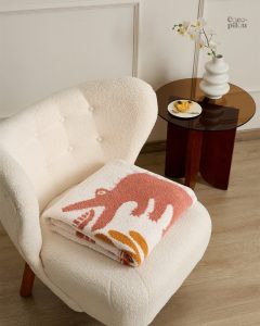 Couverture Pilou Pilou rose, idéale pour se réchauffer à la maison